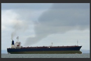A large merchant vessel emitting smoke